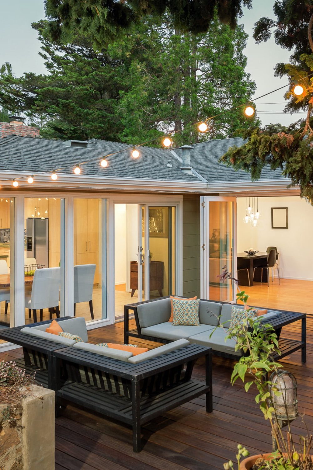 Home with furniture patio / wooden deck at twilight. Home with furniture patio / wooden deck at twilight.